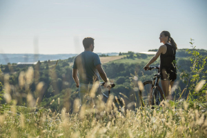 3 hommes sur un VTT en train de rigoler, en pleine nature