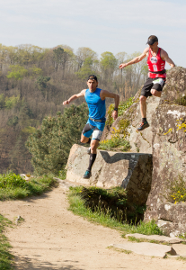 2 hommes courant et sautant d'une falaise lors d'une course en trail