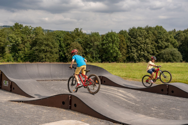 2 garçons debout sur leur VTT sur un pump track