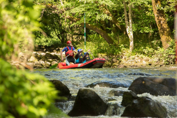 Groupe de 3 personnes sur un raft sur la Vézère en train de sourire