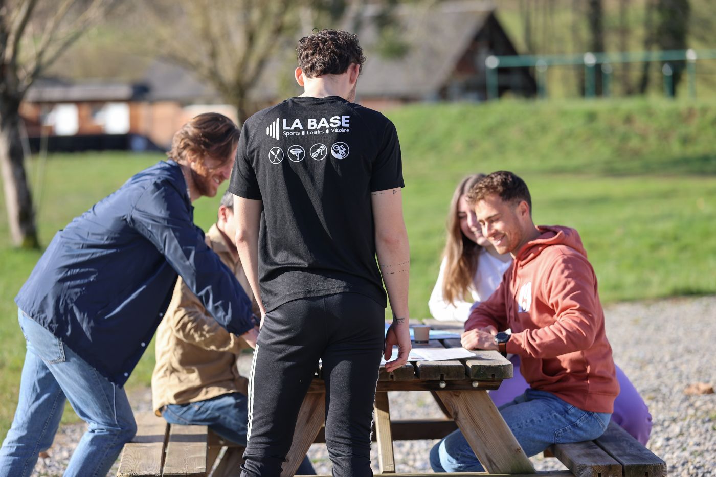 Groupe de personnes assises autour d'une table extérieure sur la terrasse de la Base